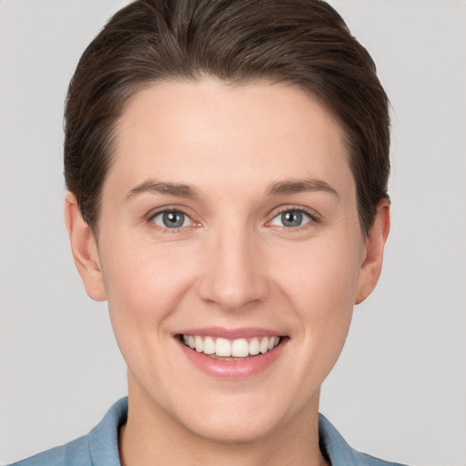 Joyful white young-adult female with short  brown hair and grey eyes