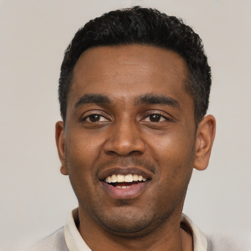 Joyful black young-adult male with short  black hair and brown eyes