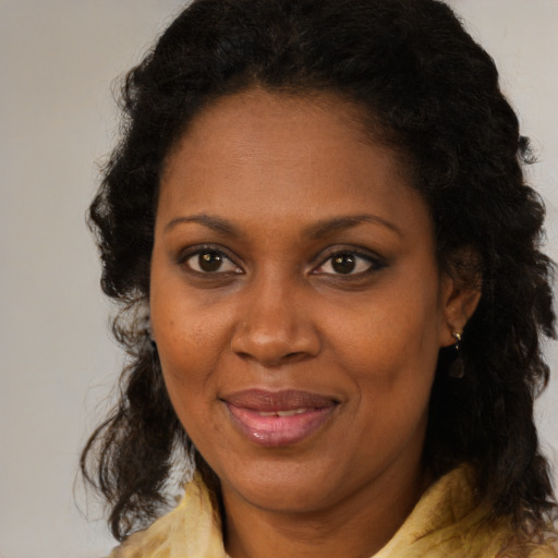 Joyful black adult female with medium  brown hair and brown eyes