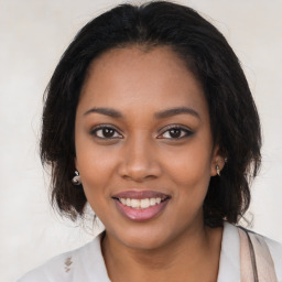 Joyful black young-adult female with long  brown hair and brown eyes