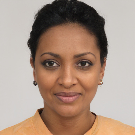 Joyful black young-adult female with short  black hair and brown eyes