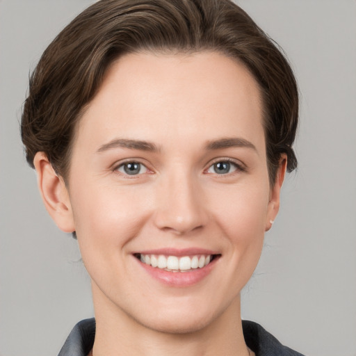 Joyful white young-adult female with short  brown hair and grey eyes