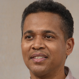 Joyful black adult male with short  black hair and brown eyes