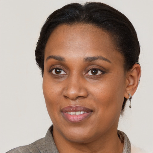 Joyful black adult female with short  brown hair and brown eyes
