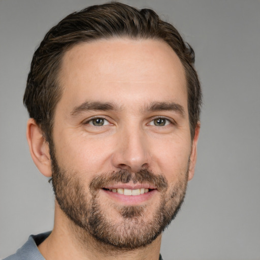 Joyful white young-adult male with short  brown hair and grey eyes