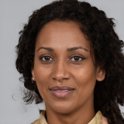 Joyful black adult female with medium  brown hair and brown eyes