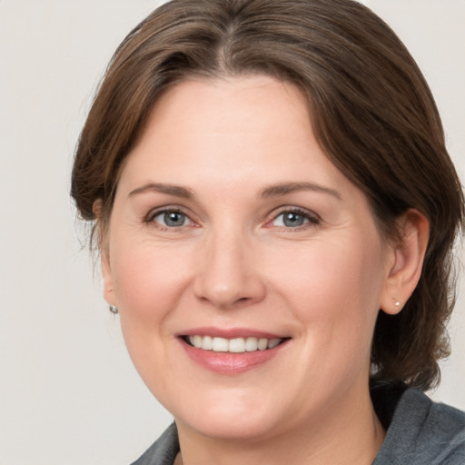 Joyful white adult female with medium  brown hair and grey eyes