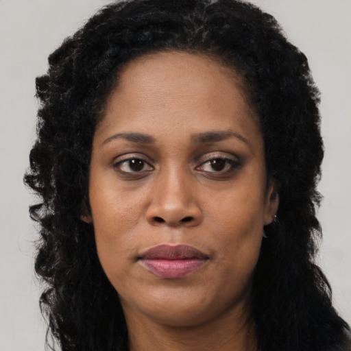 Joyful black young-adult female with long  black hair and brown eyes