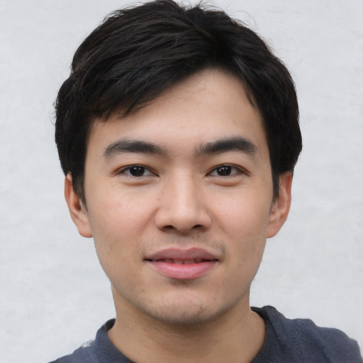 Joyful asian young-adult male with short  black hair and brown eyes