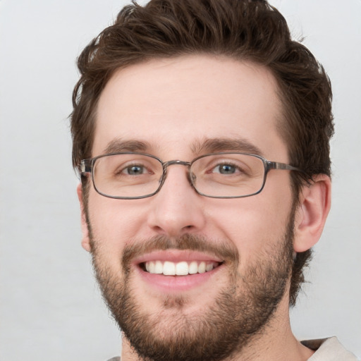 Joyful white young-adult male with short  brown hair and green eyes