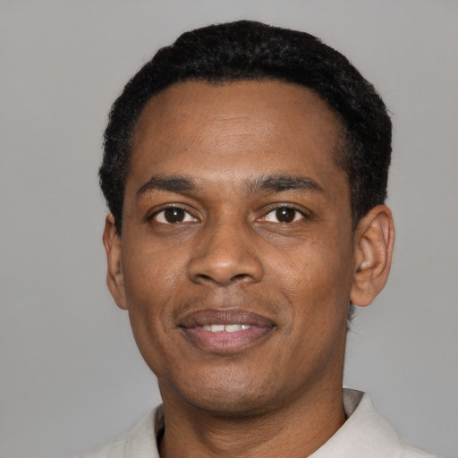 Joyful black young-adult male with short  black hair and brown eyes