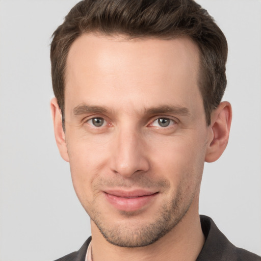 Joyful white young-adult male with short  brown hair and grey eyes