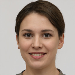 Joyful white young-adult female with short  brown hair and grey eyes