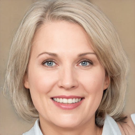 Joyful white adult female with medium  blond hair and blue eyes