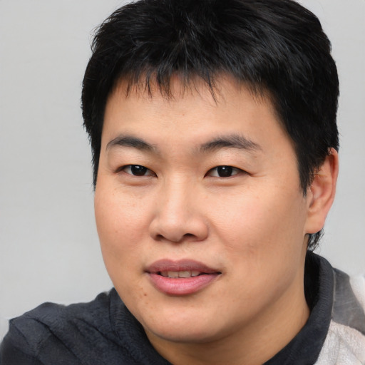 Joyful asian young-adult male with short  brown hair and brown eyes