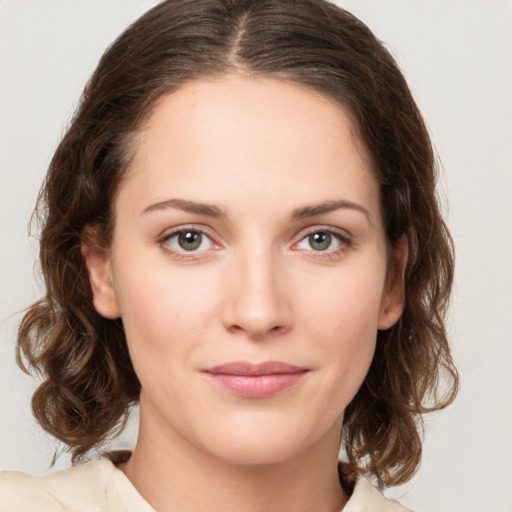 Joyful white young-adult female with medium  brown hair and green eyes