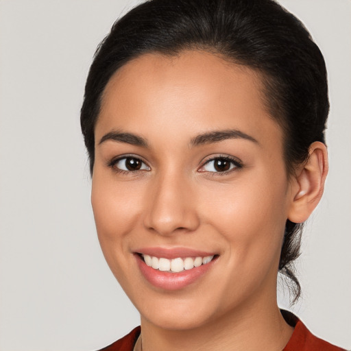 Joyful latino young-adult female with medium  brown hair and brown eyes