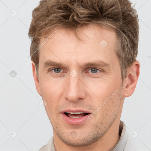 Joyful white adult male with short  brown hair and grey eyes