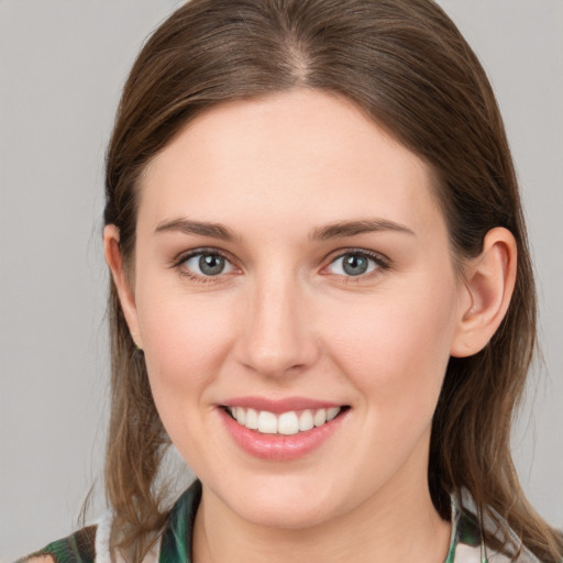 Joyful white young-adult female with medium  brown hair and grey eyes