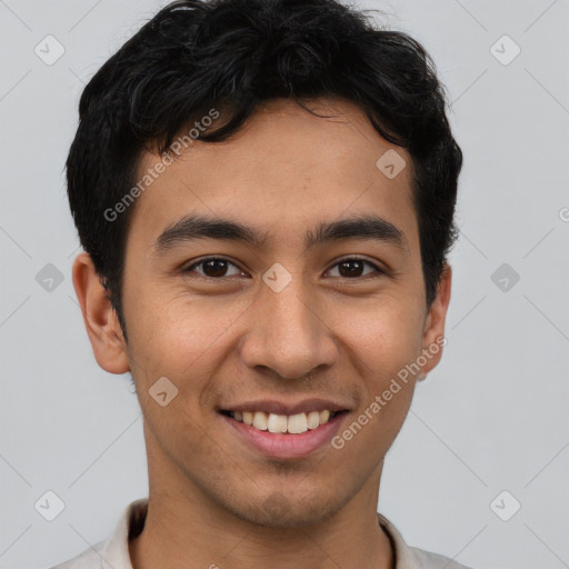 Joyful latino young-adult male with short  brown hair and brown eyes