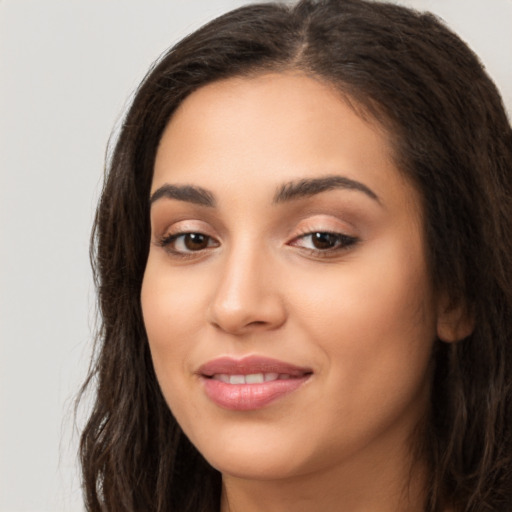 Joyful latino young-adult female with long  brown hair and brown eyes