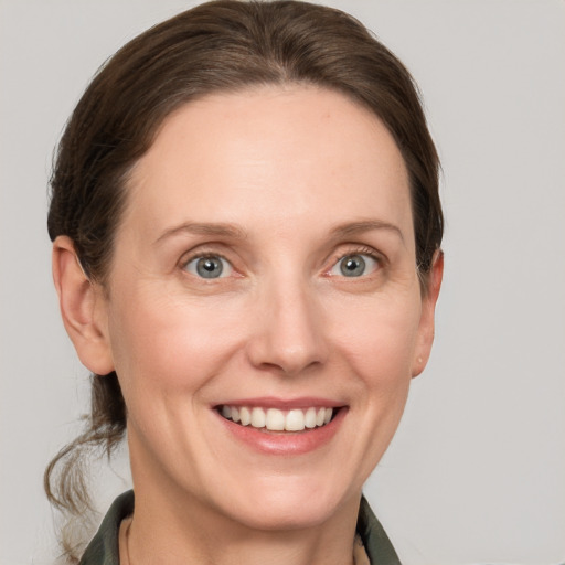 Joyful white adult female with medium  brown hair and grey eyes