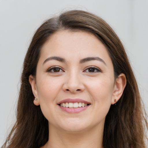 Joyful white young-adult female with long  brown hair and brown eyes