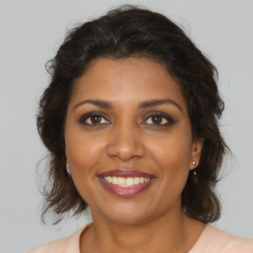 Joyful black young-adult female with medium  brown hair and brown eyes