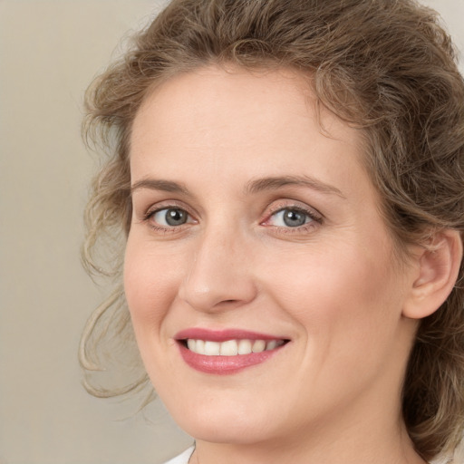 Joyful white young-adult female with medium  brown hair and green eyes