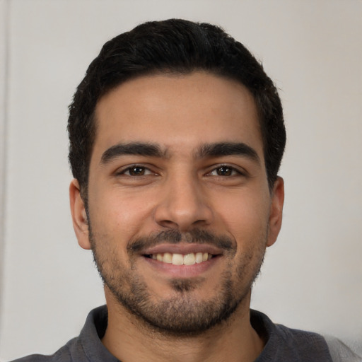 Joyful latino young-adult male with short  black hair and brown eyes
