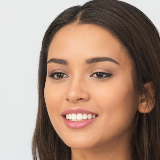 Joyful latino young-adult female with long  brown hair and brown eyes