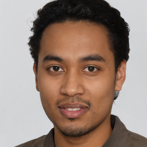 Joyful latino young-adult male with short  black hair and brown eyes