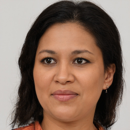 Joyful latino adult female with medium  brown hair and brown eyes