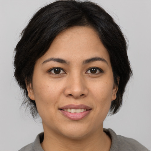 Joyful asian adult female with medium  brown hair and brown eyes