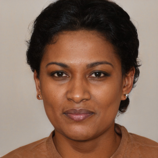 Joyful black young-adult female with short  brown hair and brown eyes