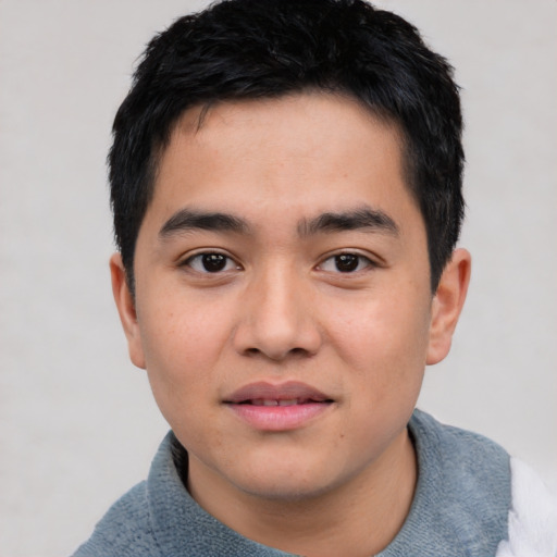 Joyful asian young-adult male with short  black hair and brown eyes