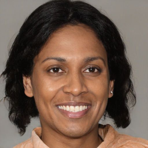 Joyful black adult female with medium  black hair and brown eyes