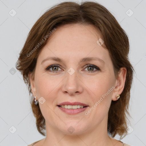 Joyful white adult female with medium  brown hair and green eyes