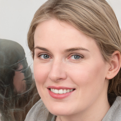 Joyful white young-adult female with medium  brown hair and blue eyes