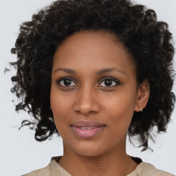 Joyful black young-adult female with medium  brown hair and brown eyes