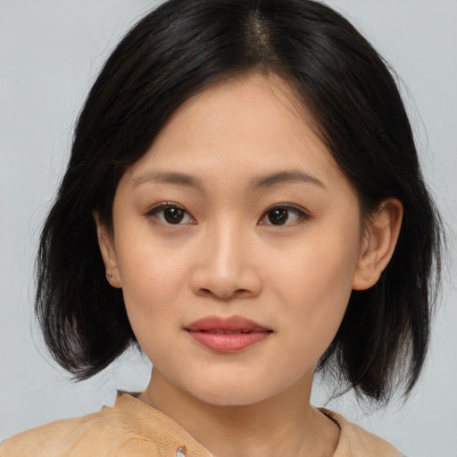 Joyful asian young-adult female with medium  brown hair and brown eyes