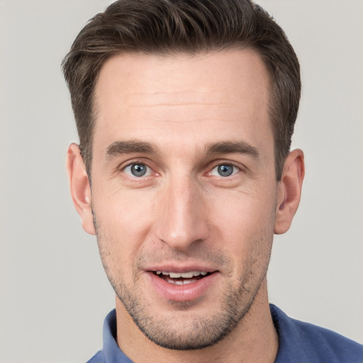 Joyful white young-adult male with short  brown hair and grey eyes