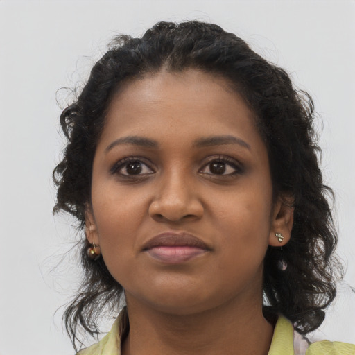 Joyful black young-adult female with long  brown hair and brown eyes