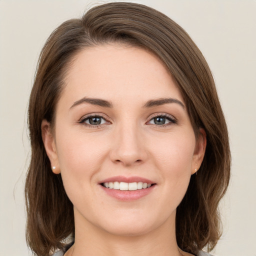 Joyful white young-adult female with medium  brown hair and grey eyes