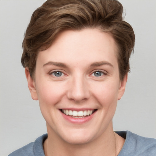 Joyful white young-adult female with short  brown hair and grey eyes