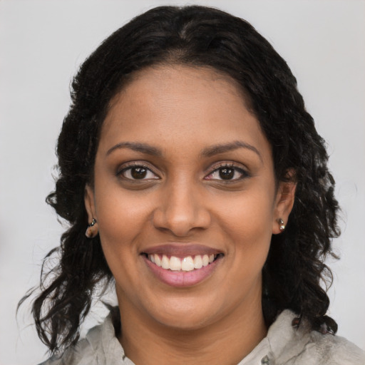 Joyful black young-adult female with long  black hair and brown eyes