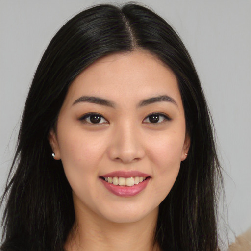 Joyful asian young-adult female with long  black hair and brown eyes