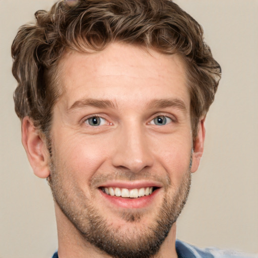 Joyful white adult male with short  brown hair and blue eyes