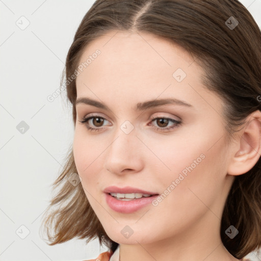 Joyful white young-adult female with long  brown hair and grey eyes