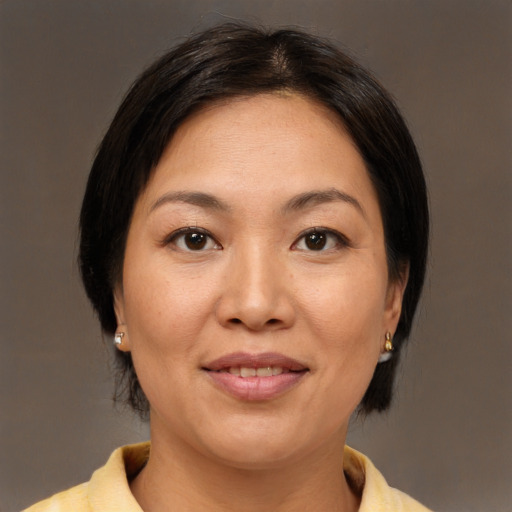 Joyful asian adult female with medium  brown hair and brown eyes